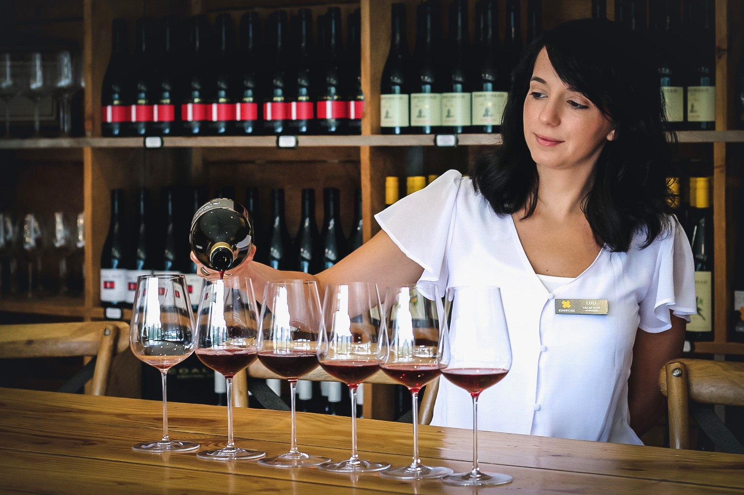 lady-sommelier-pouring-red-wine-glasses-appellation-wine-tours-host
